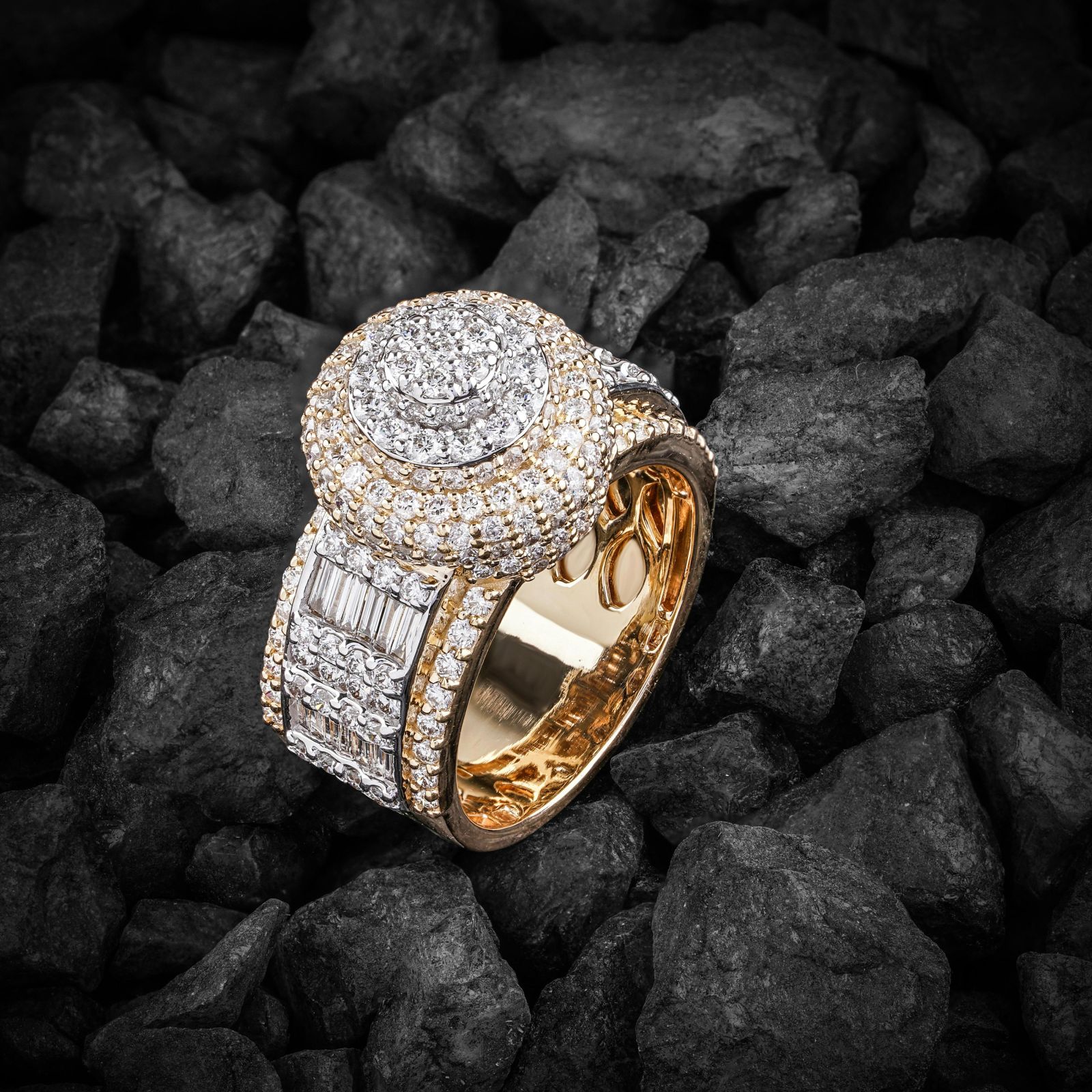 Gold ring set with diamonds resting on black coal