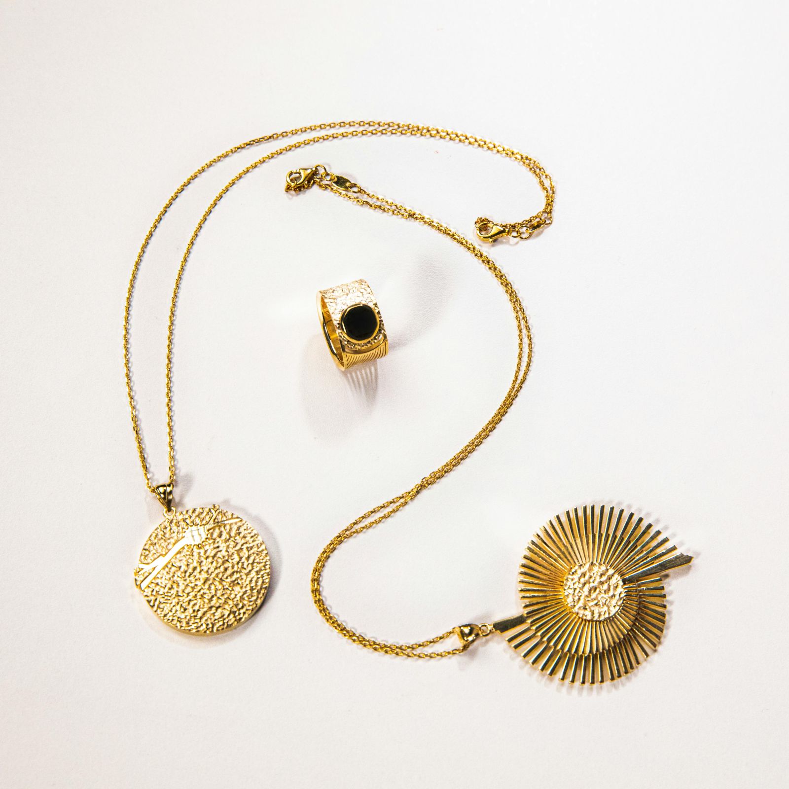 Gold coin pendant necklace with a black stone ring