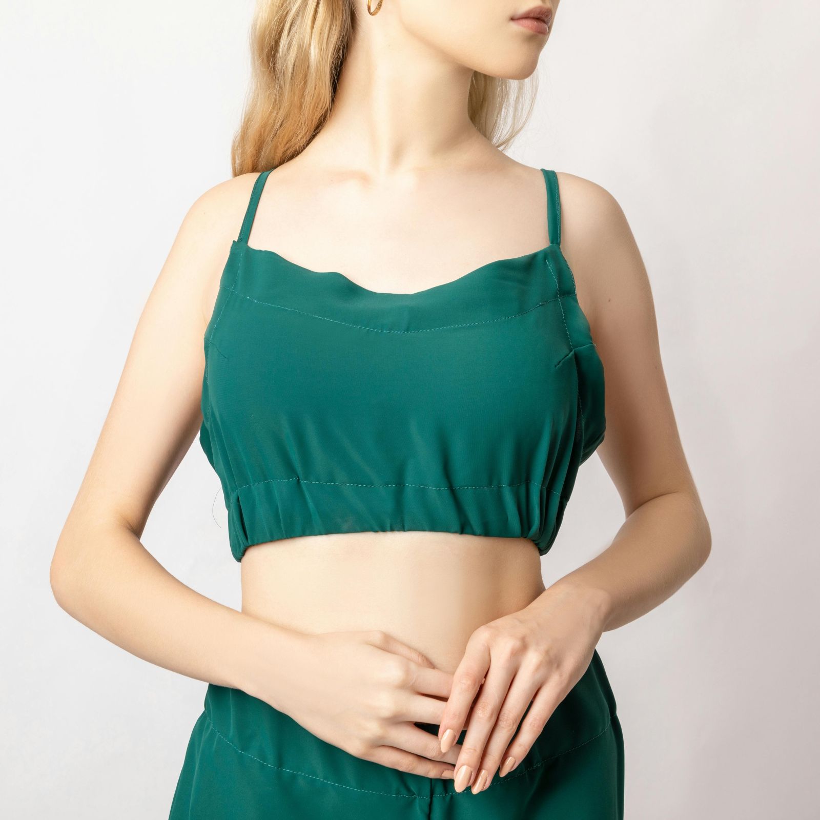 Woman in a green crop top and matching trousers