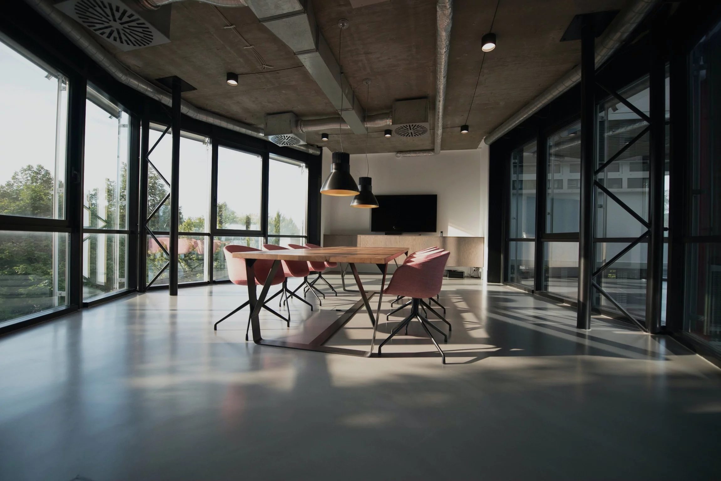 Empty open-plan office with glass walls and a long table
